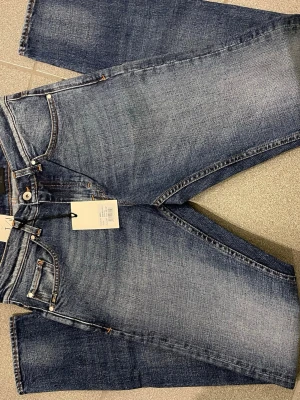 Slim fit blå jeans W29 L34 - Säljer ett par slim fit blå jeans med snygg tvätt och klassiska kontrastsömmar. Modellen har fem fickor och raka ben. Passar dig som gillar en smalare siluett och vill ha ett par stilrena jeans till garderoben.