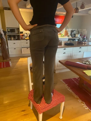 Grå mjukisbyxor från juicy couture  - Snygga grå mjukisbyxor från Juicy Couture med raka ben och breda fickor både fram och bak. Byxorna har snörning i midjan med silverfärgade detaljer och är gjorda i mjukt velourmaterial som är superbekvämt. Perfekta för chill dagar.