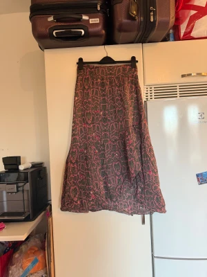 Svart och rosa långkjol med leopardmönster - Säljer en flowy långkjol med mörkgrå och rosa toner. Det rosa mönstret likande leopard lite. Men sen är även det massor av hjärtan. Tyget känns luftigt och skönt. Perfekt för dig som gillar djurmönster och vill sticka ut. Från märket Odd Molly. Storlek 1 som enligt deras storleksguide motsvarar en S. men passar en M. Mycket fint skick, jag hittar inga synliga anmärkningar eller defekter. 