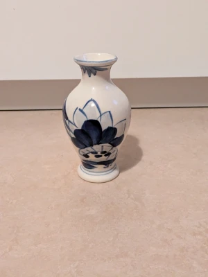 Vas - En liten vit och blå vas med ett blommönster. Vasen är mycket bra skick 