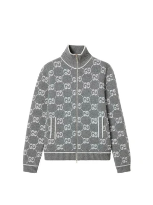 Gucci kofta - Säljer en grå kofta från Gucci med hel dragkedja och ribbade muddar. Tröjan har ett snyggt mönster med vita GG-loggor över hela och två fickor fram. Hög krage och mjukt stickat material som känns lyxigt och skönt. Perfekt för dig som gillar designer och vill sticka ut.