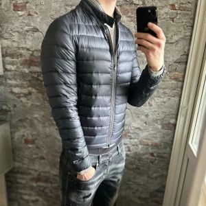 Herno lättviktsjacka - Mycket fint skick, tappat lite dun men inget tydligt. Storlek 46/S passar dig som är mellan 168-178cm ungefär. Nypris ca 4000kr. Modellen är 185 cm, 79 kg. Självklart äkta - Kolla bara recensionerna! Passar bra nu till vintern. Skriv för mer information!🤝