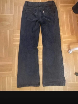 Svarta jeans från alobha label, storlek S - Snygga svarta jeans  från alobha label i klassisk femficksmodell. Byxorna har raka ben och normal passform, med stilrena sömmar på bakfickorna. Jeansen är tillverkade i robust denim och har knappstängning framtill. Perfekta för dig som gillar enkel och tidlös stil.
