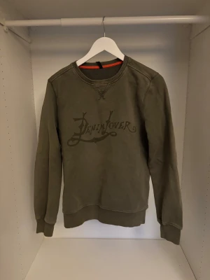 Mörkgrön tröja från nudie jeans - Säljer en mörkgrön sweatshirt från Nudie Jeans i storlek M med riktigt skönt tryck. Perfekt för dig som gillar stilrena och bekväma plagg.