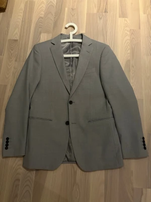 Grå Kavaj - Grå Kavaj från Dressman i Storlek 46 i nyskick. Nypris 1200kr. Vid fler frågor är det bara att höra av sig!