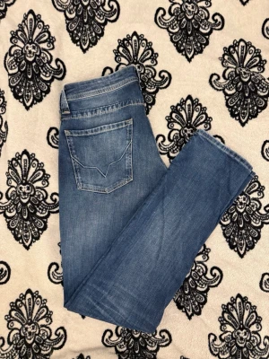 Pepe Jeans London Blå Regular Fit Jeans – Classic Denim - Klassiska blåjeans från Pepe Jeans London i normal passform.  Storlek 32/36 Midja: 42 cm Innerbenslängd: 89 cm Ytterbenslängd: 117 cm  Jeansen är i utmärkt skick och har en tidlös, ren denimtvätt som fungerar perfekt för vardagsbruk. Tillverkade av kvalitetsdenim med en bekväm passform som aldrig går ur tiden.  Lätt att styla med sneakers, stövlar eller en jacka för en avslappnad eller smart casual look. Ett perfekt basplagg för vilken garderob som helst.  Tveka inte att höra av dig! 
