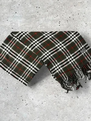 Olivgrön Burberry Halsduk - Säljer en snygg olivgrön Burberry halsduk med det ikoniska rutmönstret. Tillverkad i 100% mjuk och värmande ull.   🧵 Skick: Mycket fint skick, varsamt använd 🌟 Känsla: Mjuk, varm och följsam 📦 Frakt: Skickas tryggt inom 24h 📏 Mått: Längd-150cm, Bredd-30cm Pris kan diskuteras!