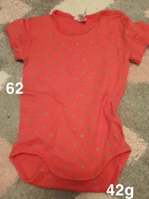 Rosa prickig body - Säljer en söt rosa body med korta ärmar och prickigt mönster. Bodyn har praktiska tryckknappar i grenen för enkel på- och avklädning. Perfekt för dig som gillar färgglada och lekfulla plagg till de minsta.🌸 Fint använt skick. Storlek 62