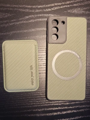 Samsung Galaxy S21 FE MagSafe-kompatibelt skal med magnetisk kortficka - Stilrent skyddsskal till Samsung Galaxy S21 i grön vävd design. Skal med MagSafe-kompatibilitet och tillhörande magnetisk kortficka. Passar perfekt, skyddar mot repor och stötar. Mycket gott skick, inga synliga defekter eller slitage.