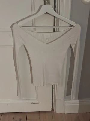 Vit ribbad offshoulder topp H&M XS - Säljer en vit ribbad topp från H&M i storlek XS. Modellen är offshoulder med lång ärm och v-ringad hals. Säljer pga att den inte kommer till användning 🥰
