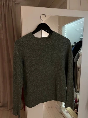 Grön stickad tröja från Vero Moda  - Säljer en grön stickad tröja från Vero Moda i storlek XS. Tröjan har rund halsringning, ribbade muddar och lång ärm. Tecken på användning men den har inga defekter. 
