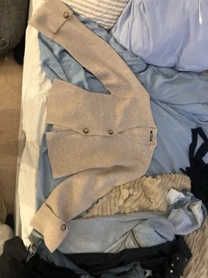 Beige kofta från Gina Tricot - Säljer denna beige kofta från Gina Tricot i storlek S då den är för stor! Har bara testat den. Koftan har lång ärm, två stora knappar framtill och breda muddar vid ärmslut. Den är stickad och har en clean, rak passform som är normal. Perfekt för lager-på-lager under hösten och vintern. Inga defekter eller något! 