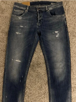 Dondup jeans - Snygga blå jeans från Dondup med slitna detaljer och tvättad look. Hör av dig om du har några frågor!