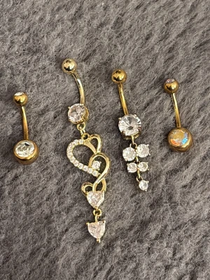 Navelpiercingar - Fyra snygga navelpiercingar i guldton med glittrande stenar ✨ Priset är för alla