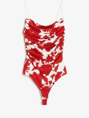 Vit och röd blommig body H&M - Säljer en snygg body från H&M med tunna axelband och draperad front. Bodyn är vit med stora röda blommor och har en figurnära passform. Perfekt för dig som gillar färgstarka mönster och vill sticka ut lite extra.