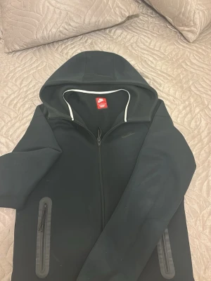 Svart Nike Tech - Svart Nike tech i Storlek S, passar perfekt till orten stilen. Sitter bekvämt och är väldigt mjuk.