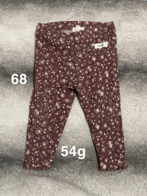 Blommiga ribbade leggings från Newbie - Supersöta ribbade leggings från Newbie med blommigt mönster. Mjukt och stretchigt material som är bekvämt för de små. Perfekta för en gullig och trendig look!🌸 Fint använt skick. Storlek 68