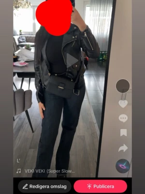 Svart axelväska med gulddetalj - Säljer min anna field väska, stilren svart axelväska i skinnimitation med guldfärgad metallspänne framtill. Väskan har en fyrkantig form, justerbar axelrem och ett litet handtag upptill. Perfekt för dig som vill ha en clean och trendig look.