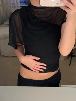 Svart mesh topp - Såå fin svart topp med cool asymmetrisk design och mesh-tyg över axlarna.😍😍❤️