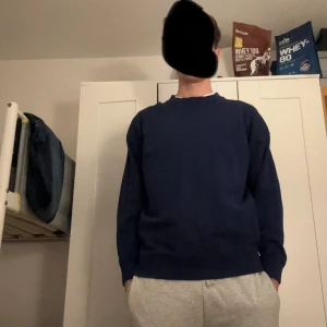 Mörkblå basic sweatshirt - En enkel och stilren mörkblå sweatshirt med rund hals och långa ärmar. Tröjan har en klassisk passform och är perfekt för en avslappnad look. Tillverkad i mjukt material som känns skönt mot huden.