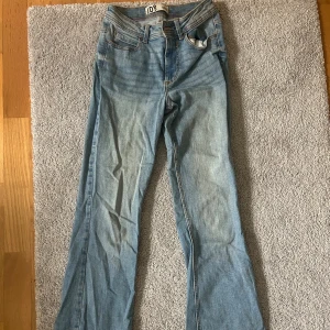 Ljusblå bootcut jeans från JDY - Säljer ett par ljusblå jeans från JDY med klassisk bootcut. Jeansen har normal passform och är tillverkade i mjukt denimtyg. Rätt så high waisted men dom går inte över naveln. Jag är 155cm och jeansen går perfekt över skorna. Jeansen är i mycket bra skick! Width 25, length 30