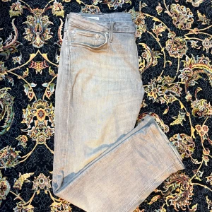 Grå jeans från Jack & Jones 33/30 - Snygga grå jeans från Jack & Jones med klassisk femficksdesign och raka ben. Jeansen har en ljusgrå tvätt och är tillverkade i mjukt bomullsmaterial med lite stretch för extra komfort. Passar dig som gillar stilrena och enkla jeans med modern look. W33 L30 