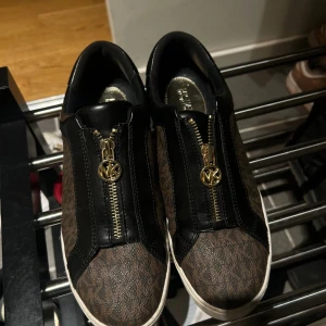 Micheal kors ZIP SLIP ON.   - Säljer mina skor från Micheal kors som inte längre kommer till använda. Köptes i år och har inte använt de så mycket. Skorna rengörs innan de skickas ut.