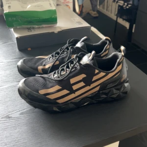 EA7 skor  - Säljer dessa otroligt snygga Armani skor i färgerna guld och svart för väldigt bra pris då dom inte passar mig längre. Skriv för fler bilder! Pris kan diskuteras.