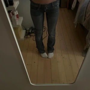 Gråa lågmidjade bootcut jeans  - Säljer ett par lågmidjade bootcut jeans                                                                     innerbenslängden: 72                                      midjemått: 32