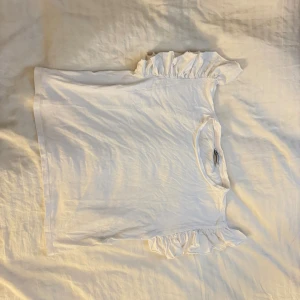 Vit volangtopp från Zara - Supersöt vit topp från Zara med volangdetaljer på axlarna.  Aldrig använd, skickas samma dag och mer bilder kan ordnas Mvh!