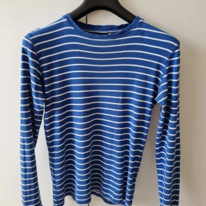 Randig långärmad tröja från Cubus strl 164 (barn) - Säljer en blå långärmad tröja från Cubus med vita horisontella ränder. Tröjan har en klassisk rund halsringning och är tillverkad i 100% bomull. Storlek 164. Kan hämtas i Vallentuna.