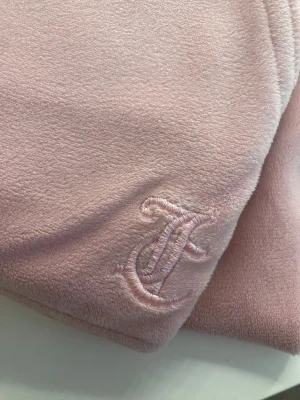 Mjukisbyxor - Ett par rosa juicy couture i storlek 15-16 år alltså storlek M dem är som nya men har endast lite fläckar där och där men det är inget som man ser jag kan annars försöka få bort det i tvätten