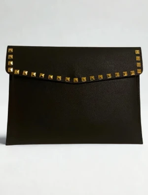 Datorfodral med guld nitar i läder imitation  - Rea – endast 199 kr (ord. pris 249 kr)! Stilrent datorfodral tillverkat av veganskt läder i vattentätt material. Fodralet skyddar din dator effektivt samtidigt som det ger din outfit en extra touch. 🫶🏻⚜️ Storlek: 34 × 25 cm – passar svarta HP Chromebooks och andra datorer i liknande storlek. 1-3 arbetsdagar leverans 📦 