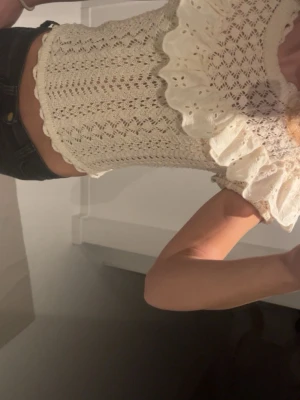 Beige stickad blus med volang från Zara - Säljer en beige stickad blus från Zara med korta ärmar och rund hals. Passar till det mesta och är knappt använd!