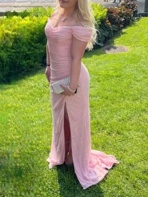 Ljusrosa glittrig långklänning offshoulder - Supersnygg ljusrosa långklänning med glittrigt tyg och offshoulder-modell. Klänningen har draperad överdel, markerad midja och slits framtill. Perfekt för bal eller fest, ger en riktigt elegant och feminin look.