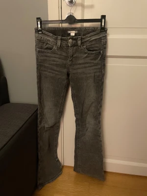 Grå bootcut jeans från Gina Tricot - Snygga grå jeans från Gina Tricot i bootcut-modell med låg midja. Storlek 158, passar bra i längd på mig som är 160 cm. En knapp saknas baktill på ena fickan, men inget man tänker på och det går lätt att gömma knappen som sitter kvar om man vill ha det symmetrisk (se bild) Jag har inte testat att sy fast en knapp eller ta bort den som sitter kvar men det borde gå jättebra 💕 säljer pga flytt och behöver rensa! 