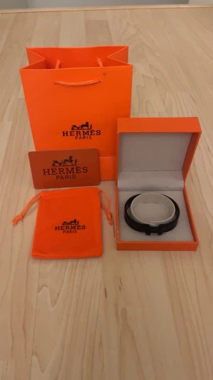 Svart H armband  - Säljer ett stilrent svart armband Med H logga och nyskick/oanvänd allt på bilden följer med