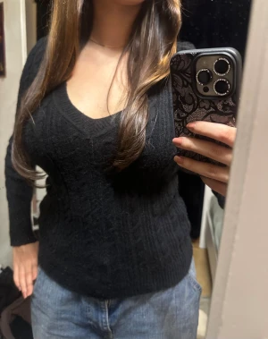 Svart stickad v-ringad tröja :) - Svart stickad tröja med v-ringning och kabelstickat mönster. Modellen är slim och har långa ärmar. Perfekt att styla med jeans eller kjol för en chill look. Mjuk och skön känsla, passar dig som gillar klassiska och enkla plagg :)