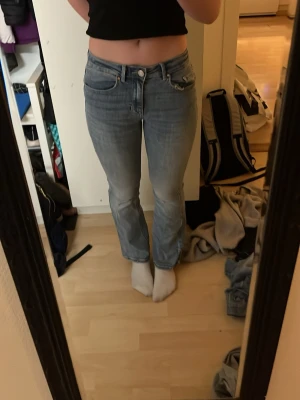 XS, Vero Moda ljusblå jeans bootcut - Säljer ett par Vero Moda jeans i ljusblå tvät med bootcut-snitt. Jeansen har normal passform och är tillverkade i mjukt jeanstyg med dragkedja och knapp framtill. Perfekt för dig som gillar retrovibe och bekväma jeans, säljs för att dom är för korta,  Fråga mig om ni undrar något😊
