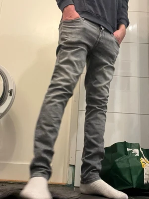 Slim Glenn grå jeans från Jack & Jones - Slim Glenn jeans från Jack & Jones i snygg grå färg. Modellen har smal passform och klassisk femficksdesign. Jeansen är tillverkade i mjukt bomullsmaterial med lite stretch för extra komfort. Perfekt för dig som gillar en modern och stilren look.