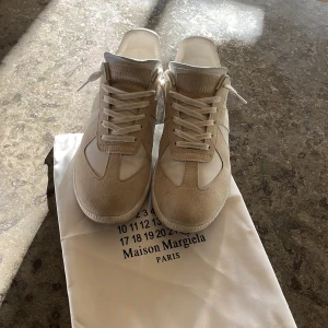 Maison Margiela gats - Maison Margiela ”gats” sneakers i beige/grå mocka och vitt skinn i storlek 44. Använda i ca 6 månader och skulle säga skicket är typ 8/10 lite jeansavfärngningar men det syns inte när man har på sig dom skulle jag säga. Kan gå ner lite i pris vid snabb och smidig affär✅ Hör gärna av er vid frågor!