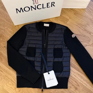 Svart Moncler cardigan jacka - Svart Moncler cardigan i storlek xxs, inköpt i augusti 2024 och är sparsamt använd. Kartong, påse och digitalt kvitto medföljer så självklart äkta. Inköpt på moncler’s hemsida för 9505kr💕även upplagd på vinted