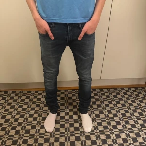 Replay anbass jeans - Säljer ett par mörkblå skinny jeans från Levis med klassisk femficksdesign och snygga slitningar. Jeansen har låg midja och smal passform hela vägen ner. Perfekta för dig som gillar en modern och stilren look.