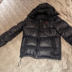 Polo Ralph lauren jacka navy blue 🔹 - Säljer min fina vinterjacka som är i storlek S. Den passar även m väldigt bra och är en perfekt vinterjacka till dig som vill ha något snyggt och endå hålla dig varm.  Den är modellen glossy blue och glänser. Den har endast ett litet hål på baksidan som knappt syns, och på bilden ser ni hur stort hålet är jämfört med mitt finger.    Den är äkta och köp på Best of brands för 6099kr. Nypris på denna jacka är 6099kr och mitt pris: endast 5000kr. Super bra skick 10/10