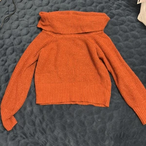 Rostbrun stickad  Gina Tricot - Mysig rostbrun stickad polotröja från Gina Tricot i storlek XS. Tröjan har en bred polokrage, ribbad struktur och långa ärmar. Perfekt för kyliga dagar och enkel att styla med jeans eller kjol.