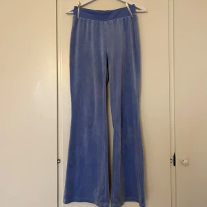 Ljusblå velourbyxor från Divided H&M XS - Mysiga ljusblå velourbyxor i Juicy-stil från Divided H&M i storlek XS. Byxorna har bred resår i midjan och utsvängda ben. Något slitna nedtill vid anklarna.