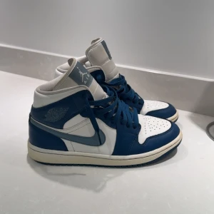 Nike Air Jordan 1 Mid blå/vit - De har en liten urgröpning vid stortårna men bara man lägger en egen sula så är problemet borta❤️jag har även dragit bort ett klistermärke på sulan därav färgskillnadeen❤️