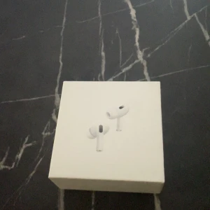 AirPods Pro - Säljer ett par Apple AirPods Pro i originalförpackning. Komplett med laddningsetui, laddkabel och extra öronproppar. Hörlurarna och tillbehören ser ut att vara i mycket gott skick, inga synliga repor eller skador. Perfekt för trådlös musik och samtal med aktiv brusreducering.