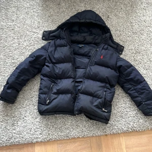 Mörk blå pufferjacka Polo Ralph Lauren - Säljer nu min raulph lauren jacka då den har blivit för liten. Den är äkta finns några små märken men inget man tänker på alls. Jättebekväm och har haft den ungefär 1 år. Passade mig när jag var 160 men är lite smalare också. Hör av er för mer frågor mvh Elton 