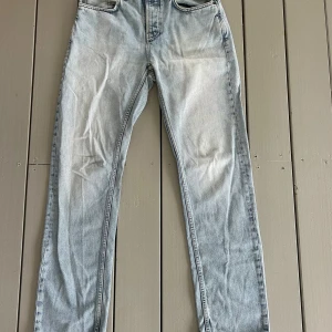 Ljusblå jeans från Nudie Jeans 28/32 - Säljer ett par ljusblå jeans från Nudie Jeans i storlek 28/32 men sitter större midjan. Klassisk femficksmodell med snyggt slitna detaljer och kontrastsömmar. Jeansen har rak/relaxed passform och är tillverkade i bomull. Perfekta för en avslappnad och trendig look.